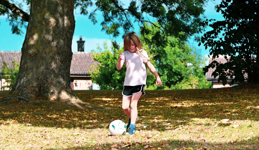 a girl kicking a football ball
