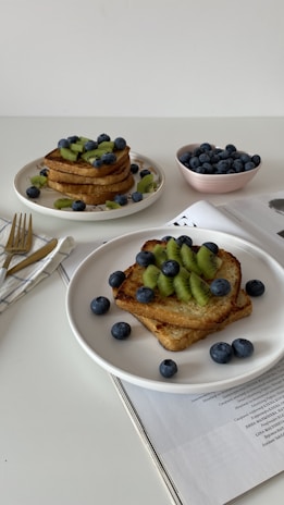 A simple breakfast plate with fresh fruit and toast on a sunlit kitchen counter.