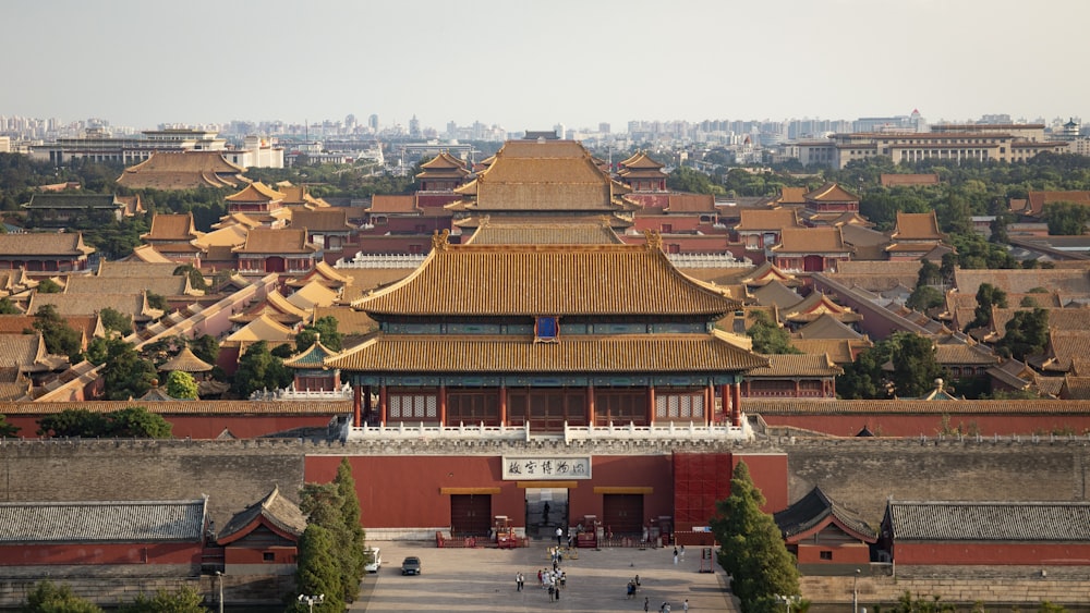 a large red building with many windows with Forbidden City in the background