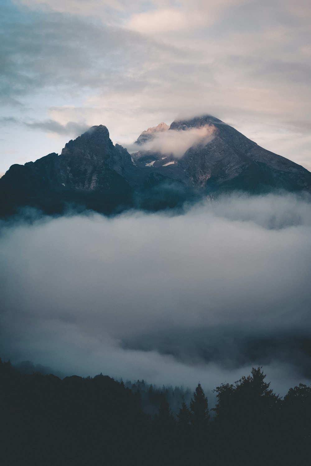 Une montagne avec des nuages en contrebas