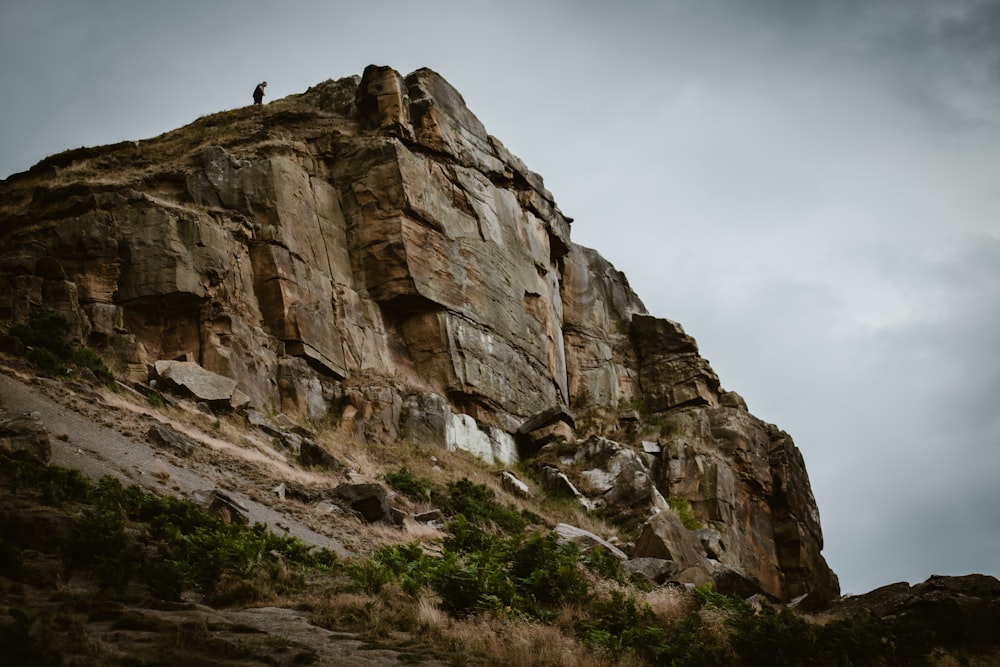 una persona in piedi su una montagna rocciosa