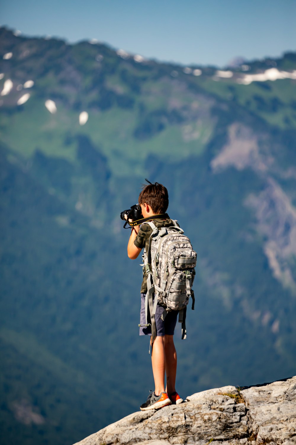 a man with a camera on a mountain