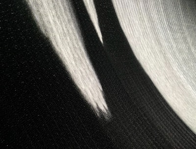 Abstract black and white image showing shadows and light playing on textured surfaces.