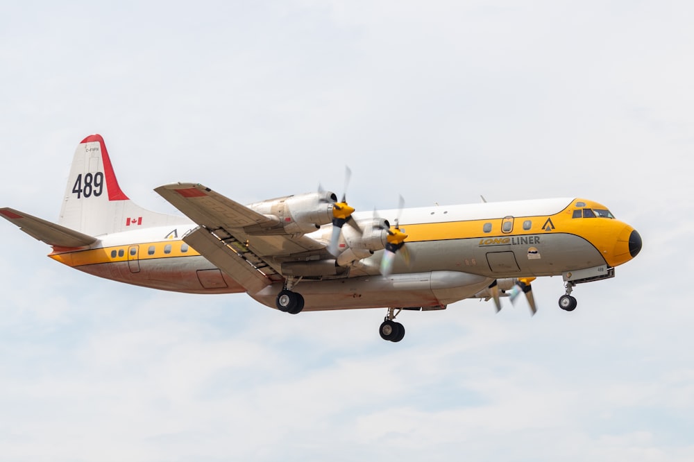 a yellow and white airplane flying