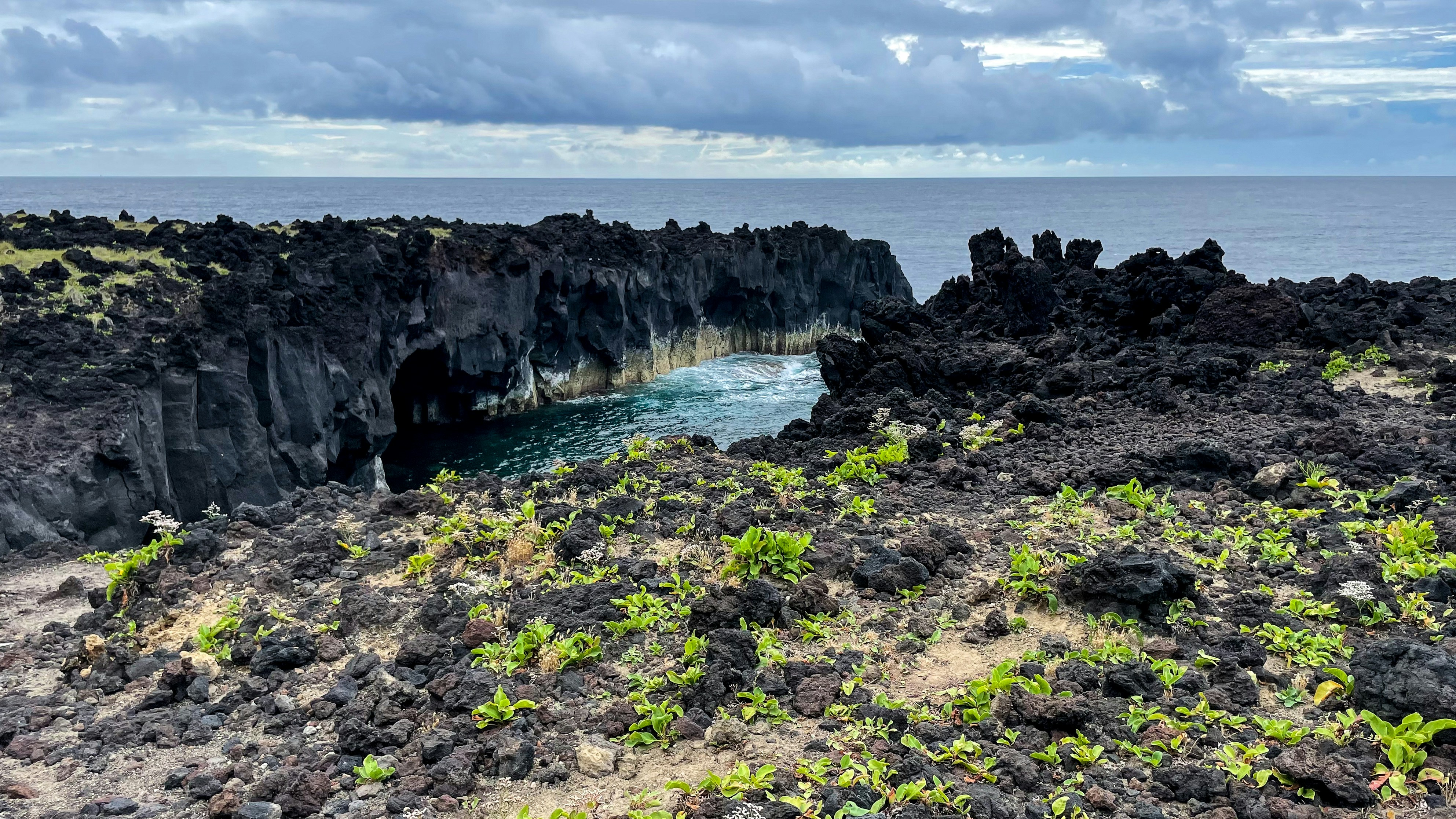 a rocky beach with a body of water in the background, 