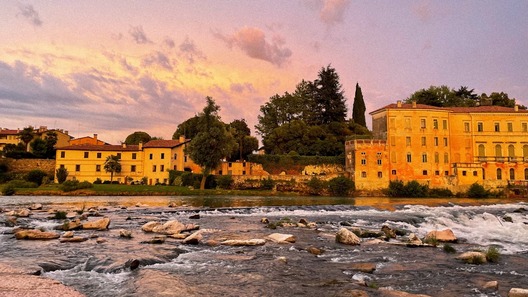 a river with rocks and buildings along it,