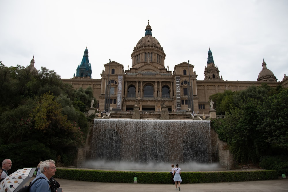un grande edificio con una fontana di fronte con il Museu Nacional d'Art de Catalunya sullo sfondo