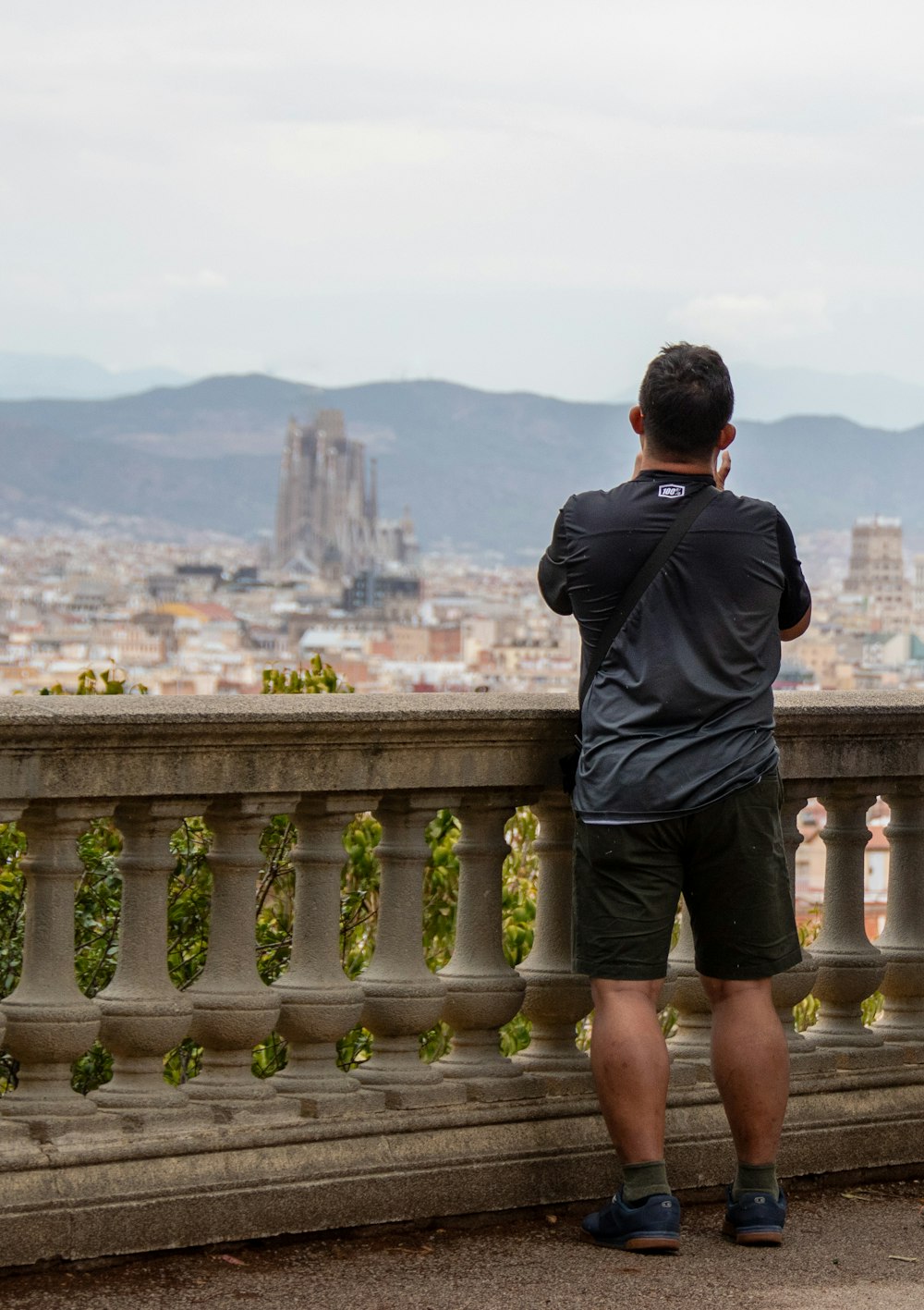 a man standing on a ledge overlooking a city