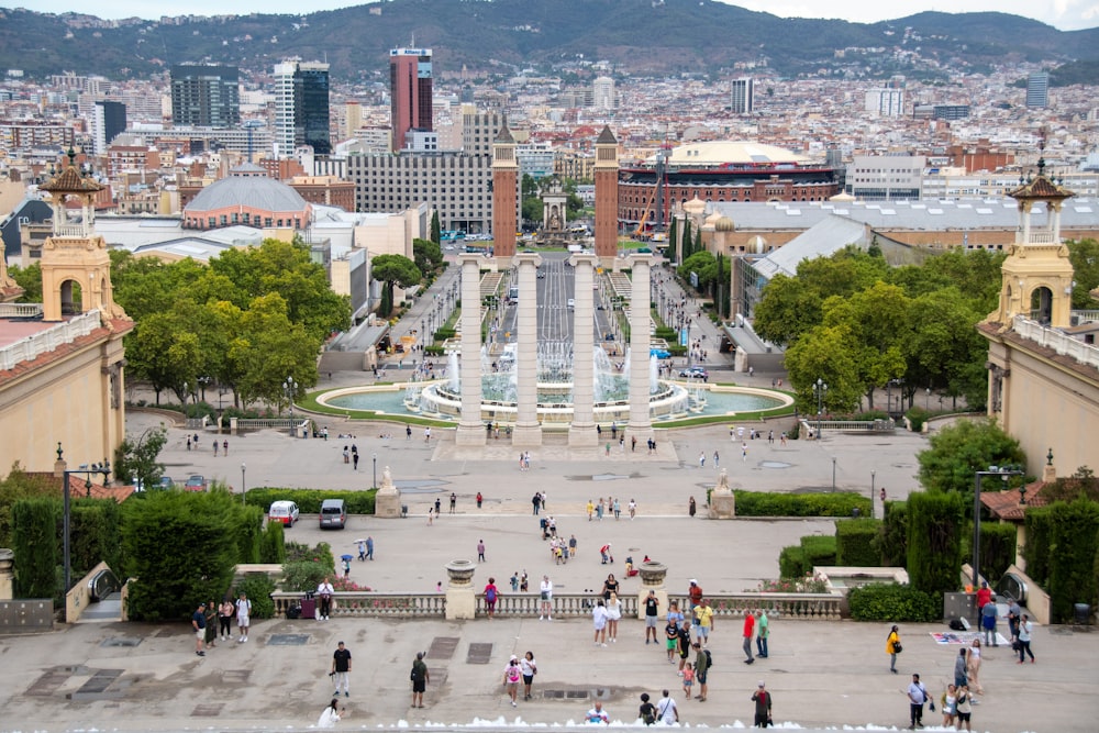 a large courtyard with a fountain and people walking around it