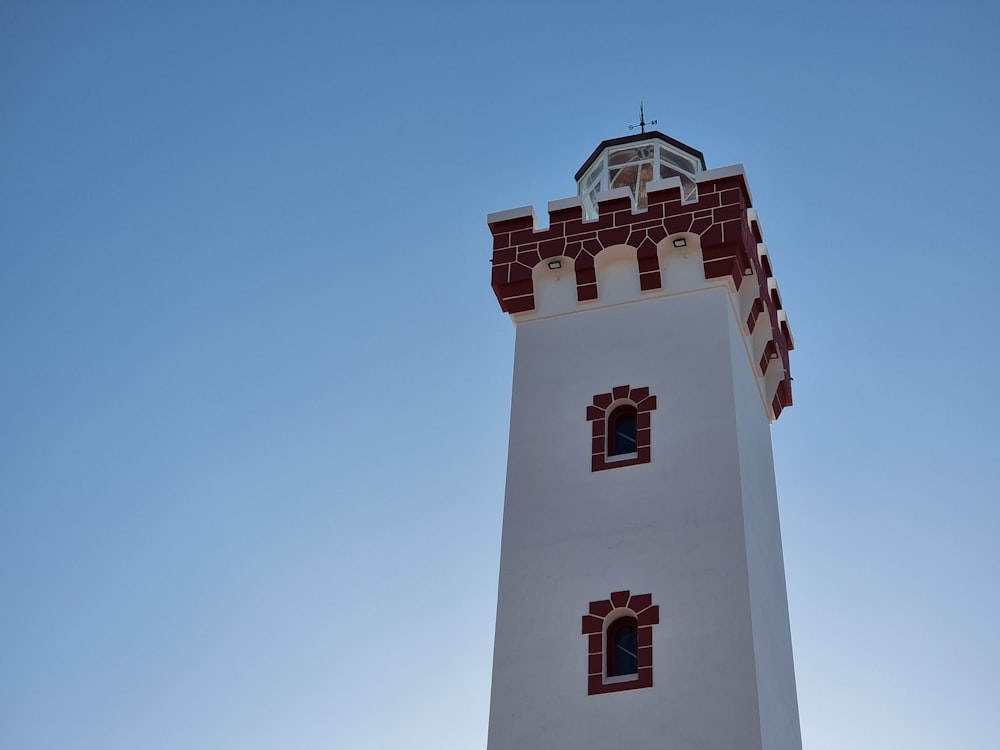 a white tower with a red and white top