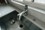 The counter top of white marble showing a SS plug which would be covered with a splash pad.