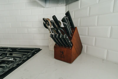 A collection of kitchen knives in various sizes and colors displayed on a kitchen counter.