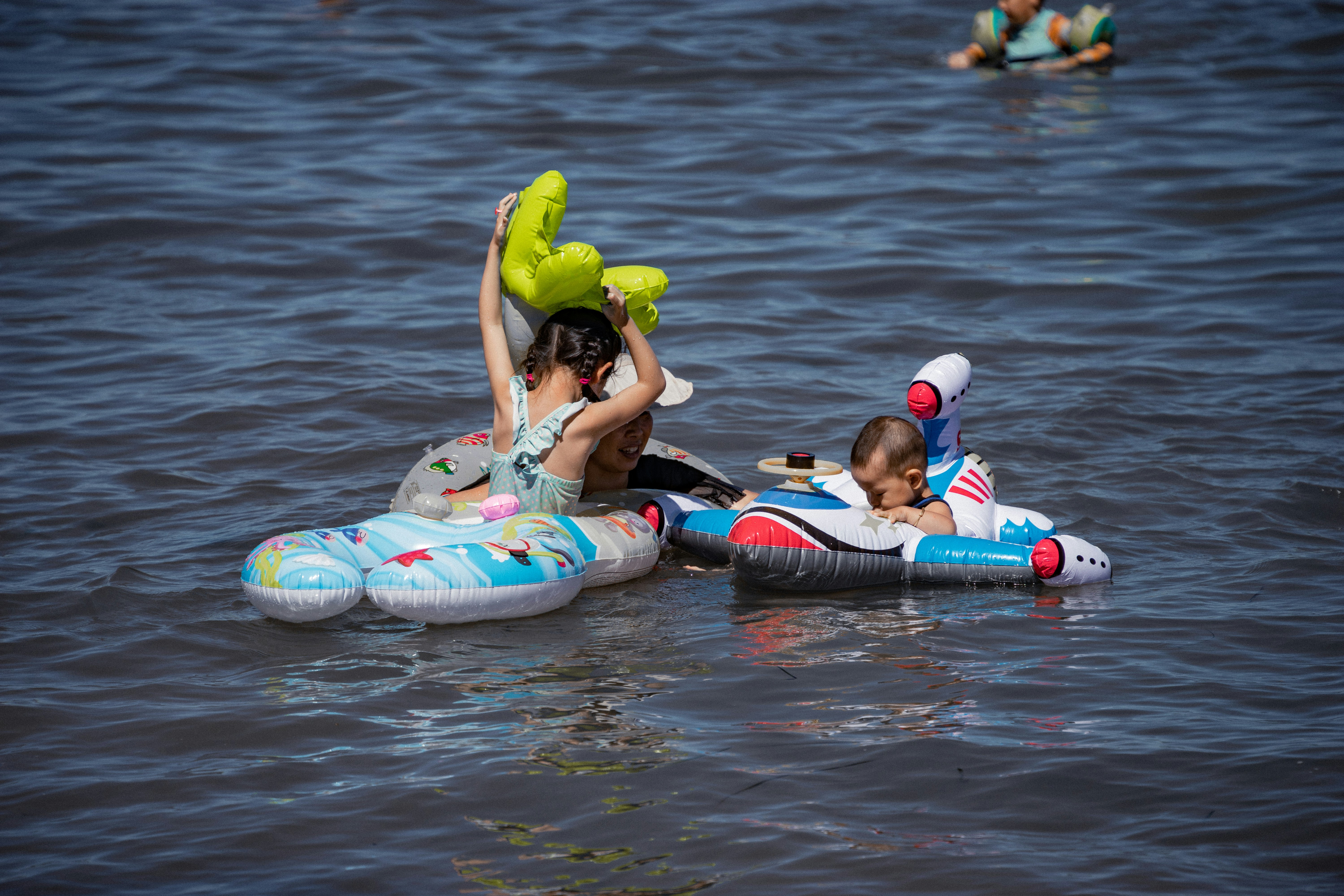 A group of kids on a floaty in the water photo – Free Water Image on ...