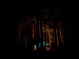 A peaceful campsite at dusk, with tents and caravans illuminated by soft lights.