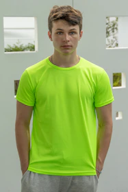A fit person measuring waist with a tape in neon green lighting.