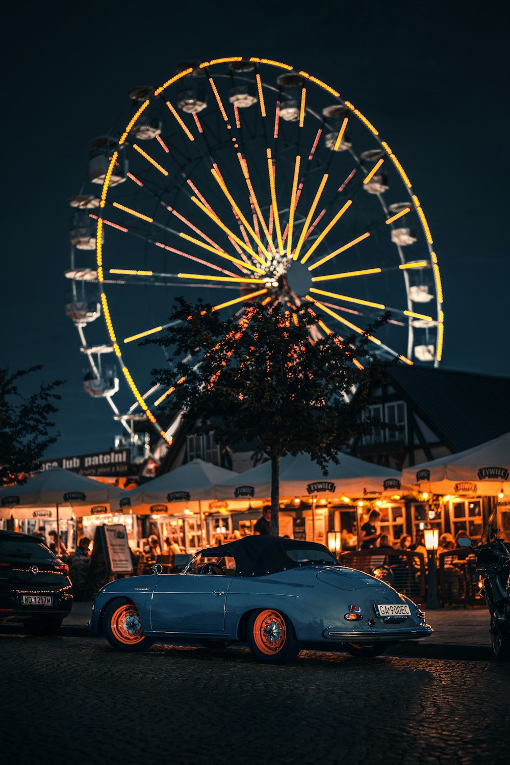 a car parked in front of a ferris wheel