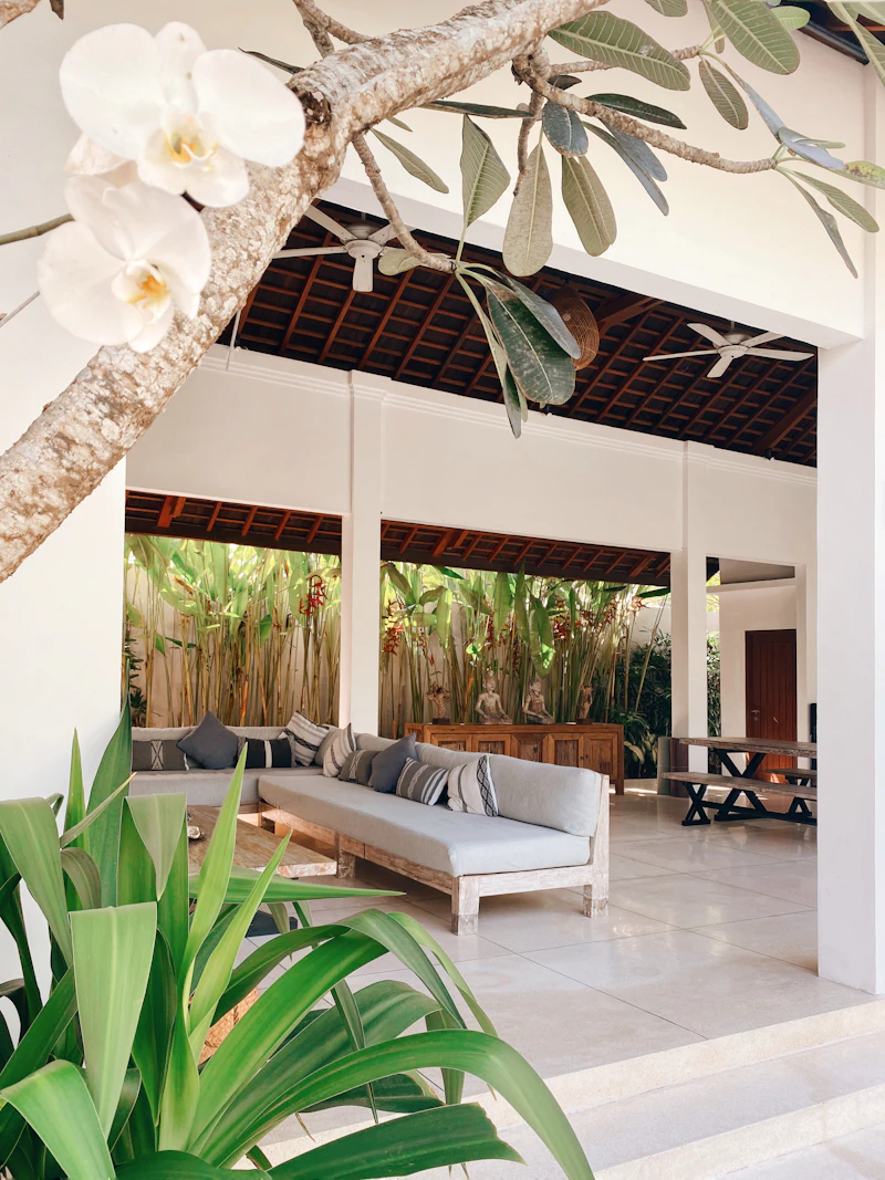Open-air villa living room with tropical plants