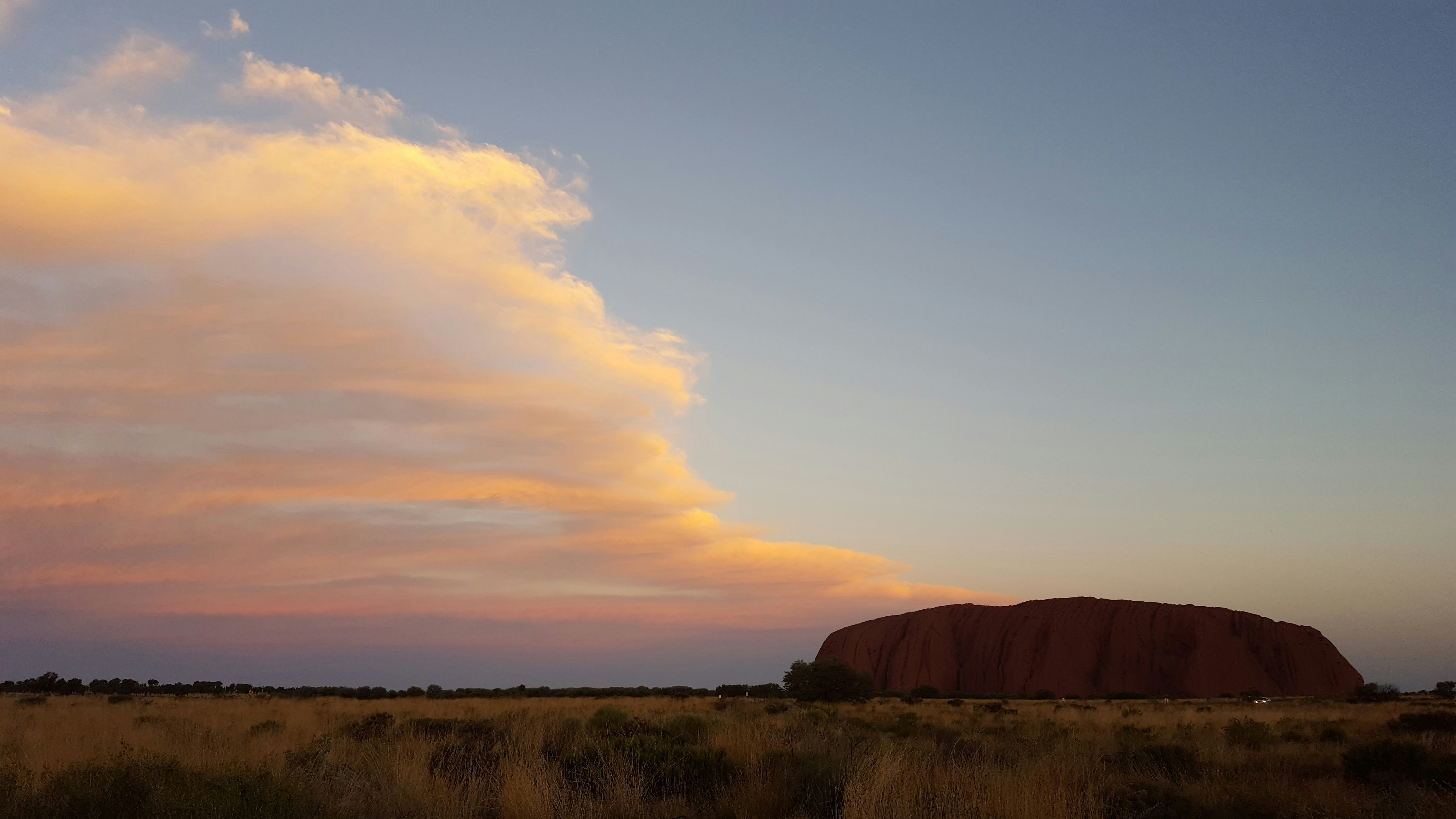 a large red rock in a field
