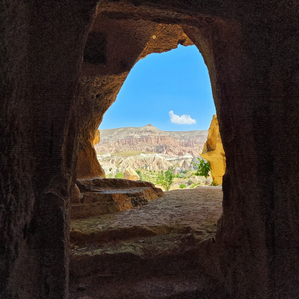 a view through a hole in a rock wall at a city