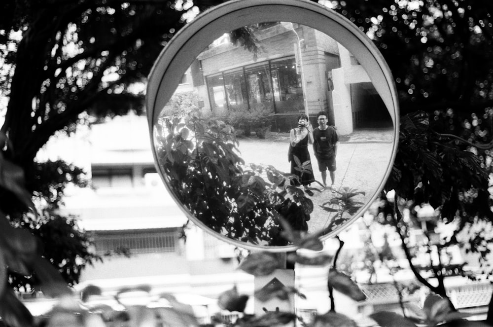 a man and woman standing in a large reflective ball