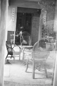 Black and white photo of a custom wooden chair and table set in a cozy room.