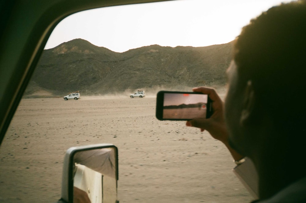 a person taking a picture of a desert