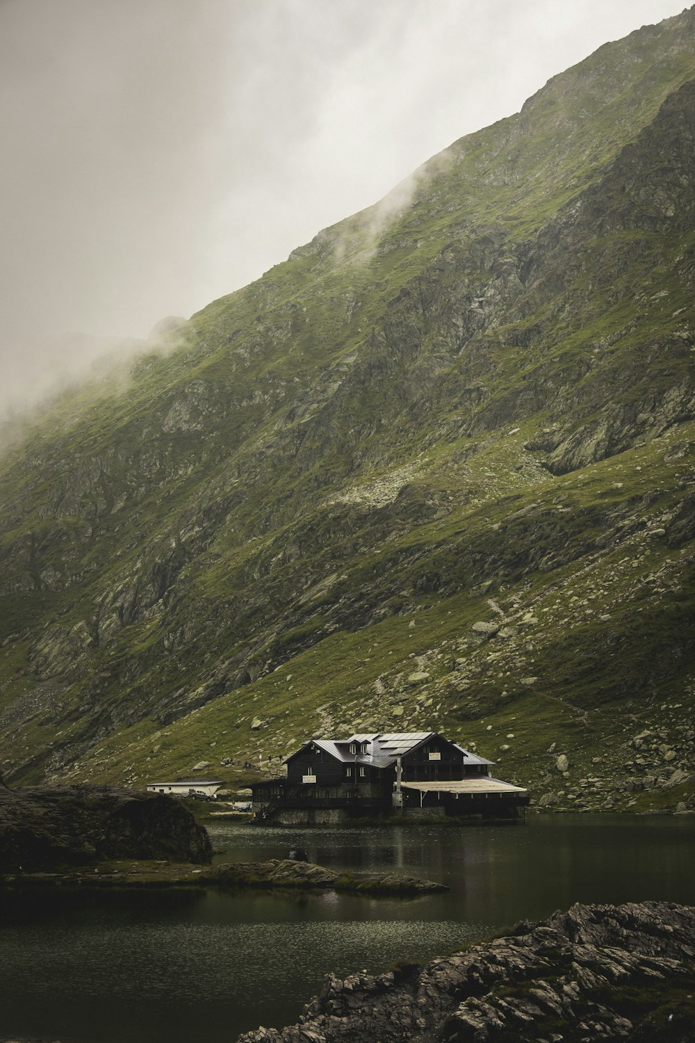 a house on a hill by a lake