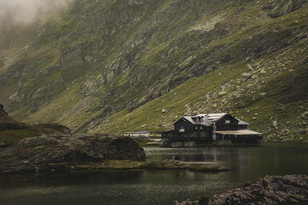 a house on a cliff by a lake