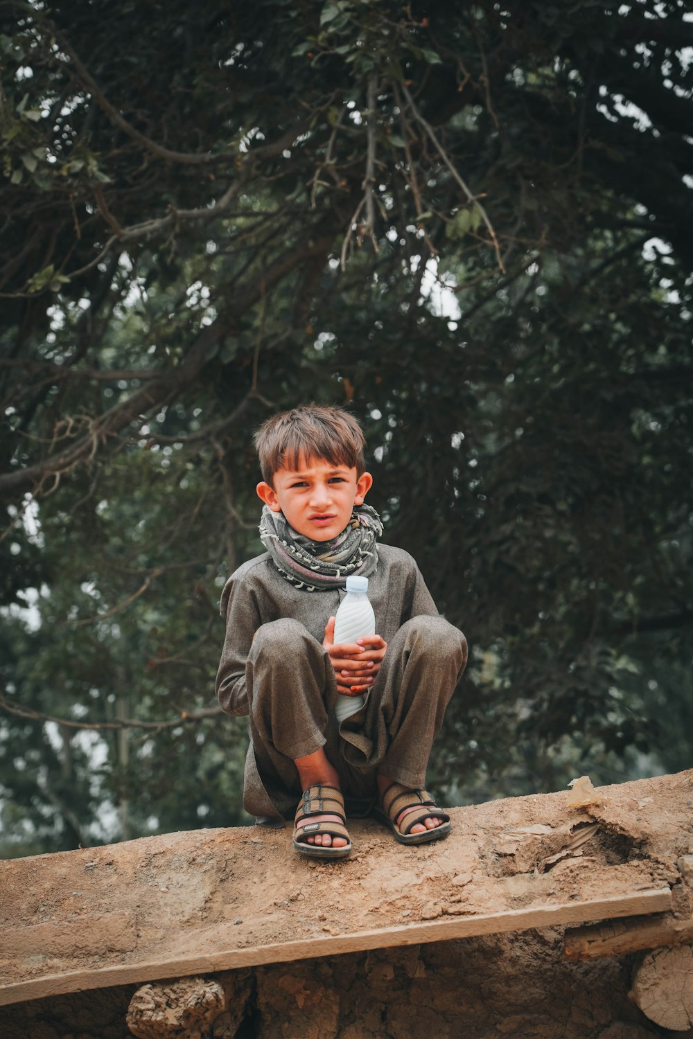 a boy sitting on a log