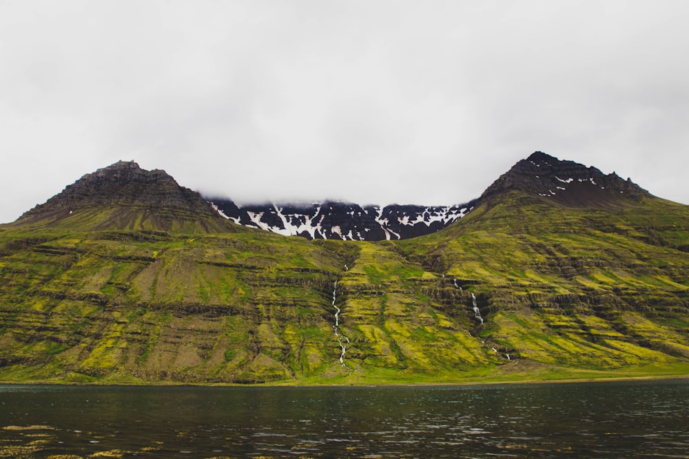 a body of water with mountains in the back