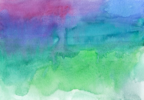 A watercolor abstract painting featuring fluid, blended washes of color across the canvas, predominantly in shades of green, blue, and purple. The transitions between colors are smooth and create a calming gradient effect.