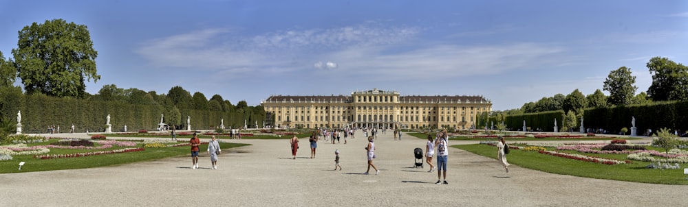 a group of people walking in a courtyard with a building in the background