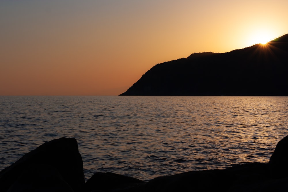 a body of water with a hill in the background