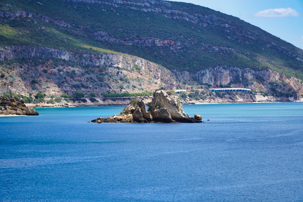 a body of water with a bridge and a mountain in the background