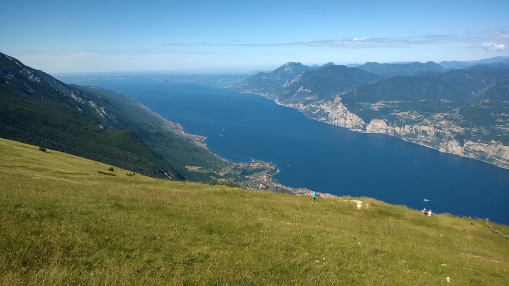 a grassy hill overlooking a body of water