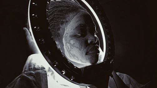 Applying textured paint and stains to a mask under moody lighting.
