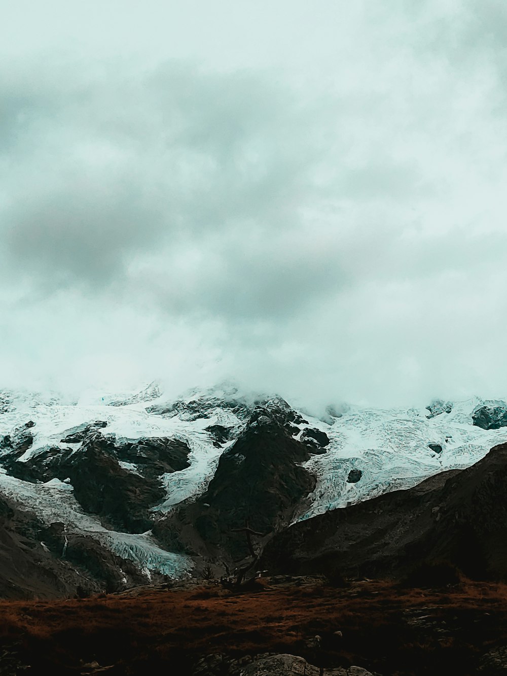 Une montagne enneigée avec des nuages