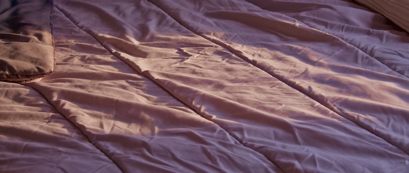 a bed with a pink sheet