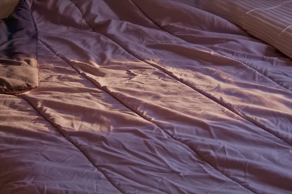 a bed with a pink sheet