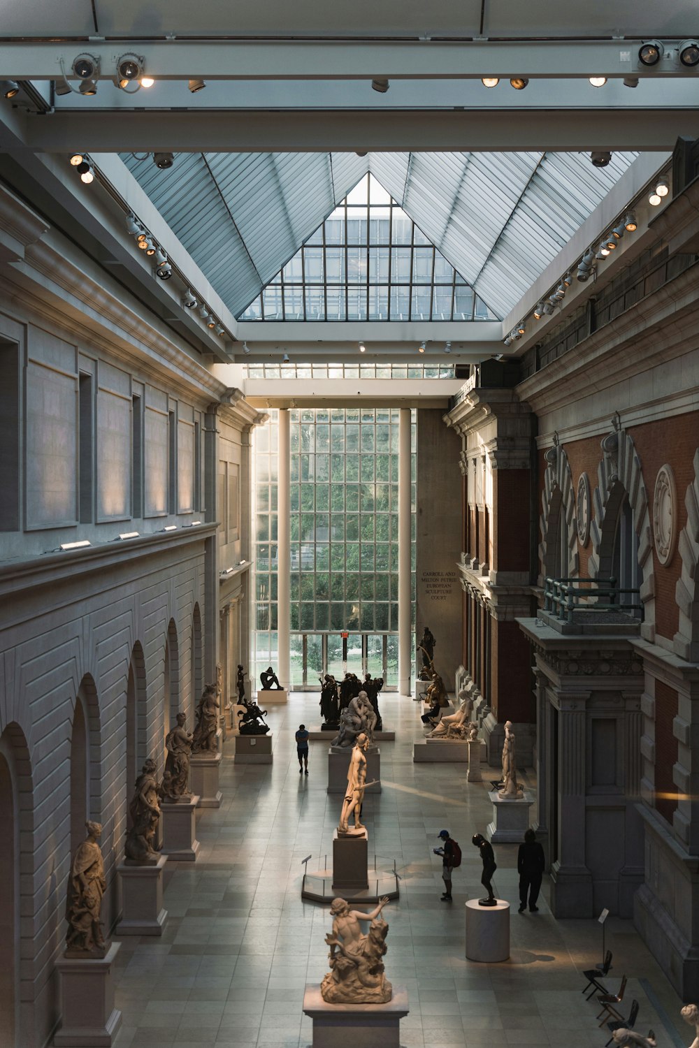 a large room with statues and people