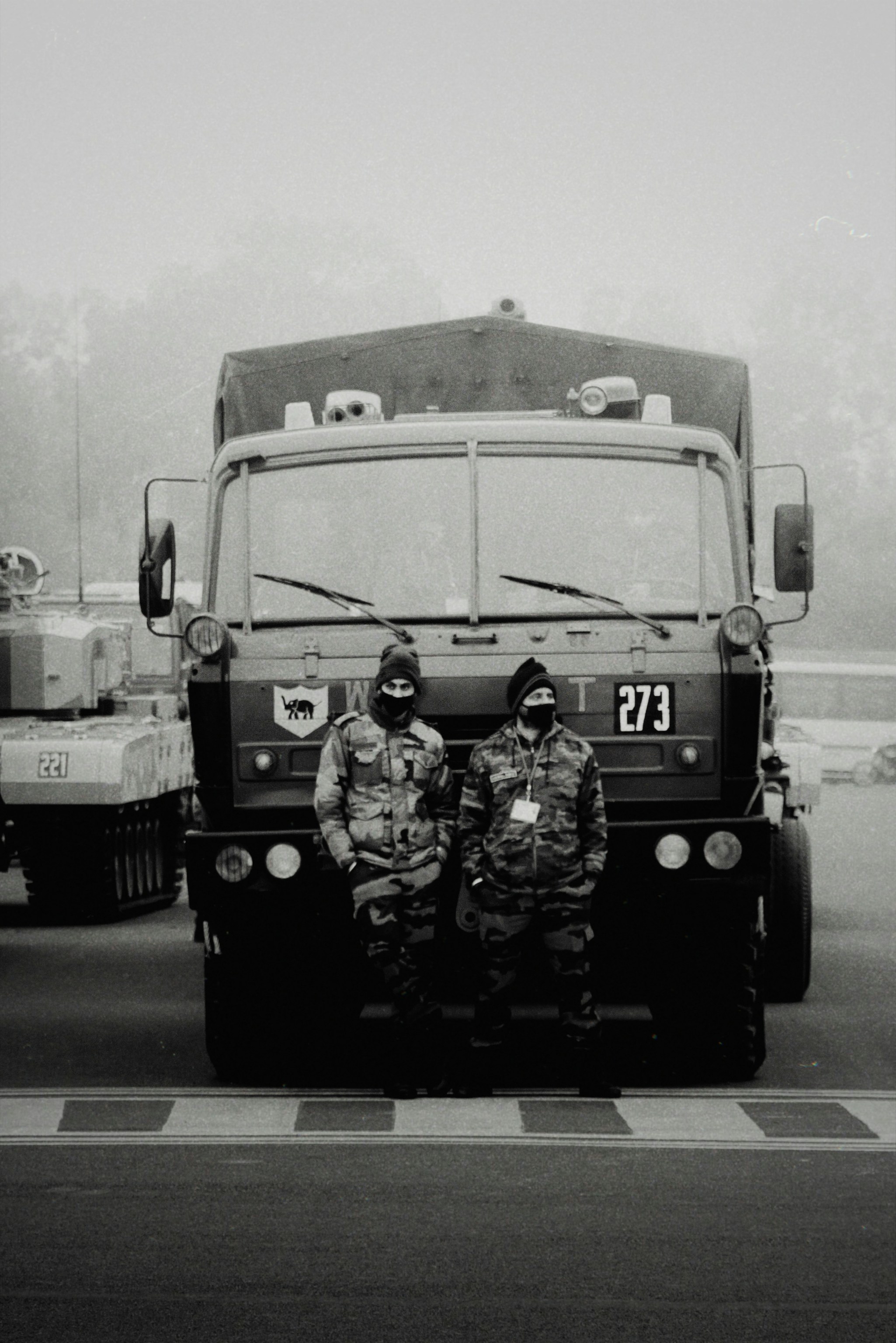 a couple of men in uniform standing in front of a large truck