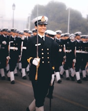 a man in a uniform with a group of people in the back