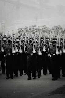 Old black and white photograph of soldiers marching in parade.