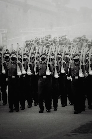 Old black and white photograph of soldiers marching in parade.