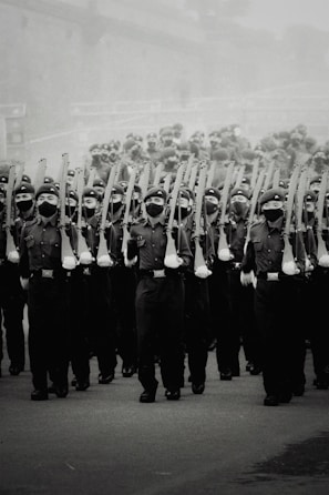 Historic black and white photo of soldiers marching during a past war