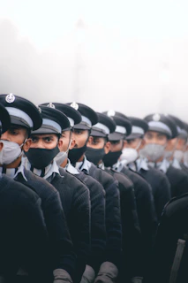 A group of volunteers wearing black masks standing together, their faces hidden but their purpose clear.