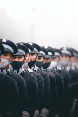 A group of volunteers wearing black masks standing together, their faces hidden but their purpose clear.
