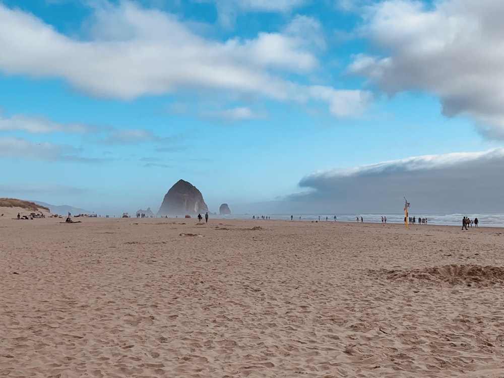 a sandy beach with people and a tent