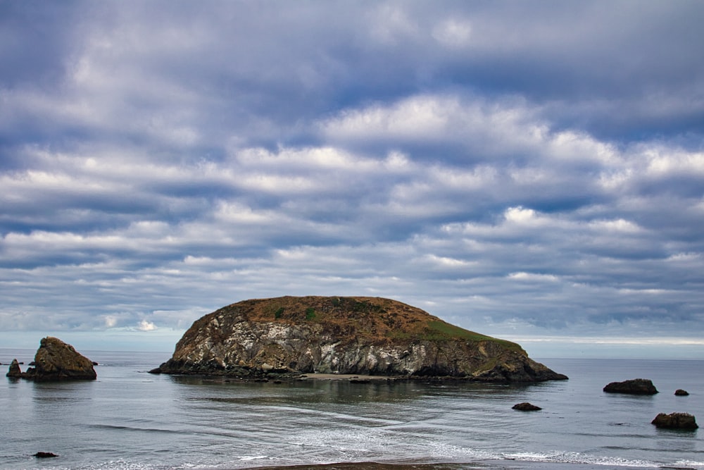 a large rock in the middle of a body of water