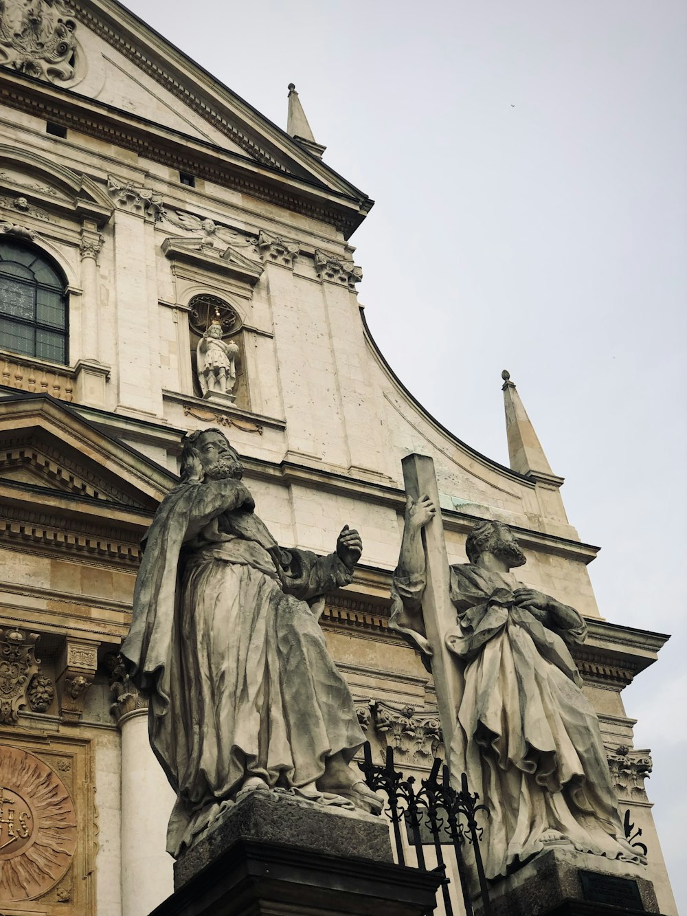 a statue of a person holding a staff in front of a building